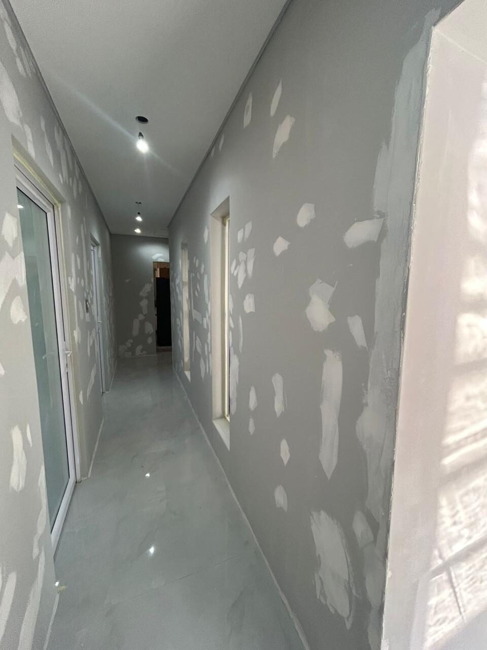 Hallway mid-renovation, walls skim-coated ahead of paint