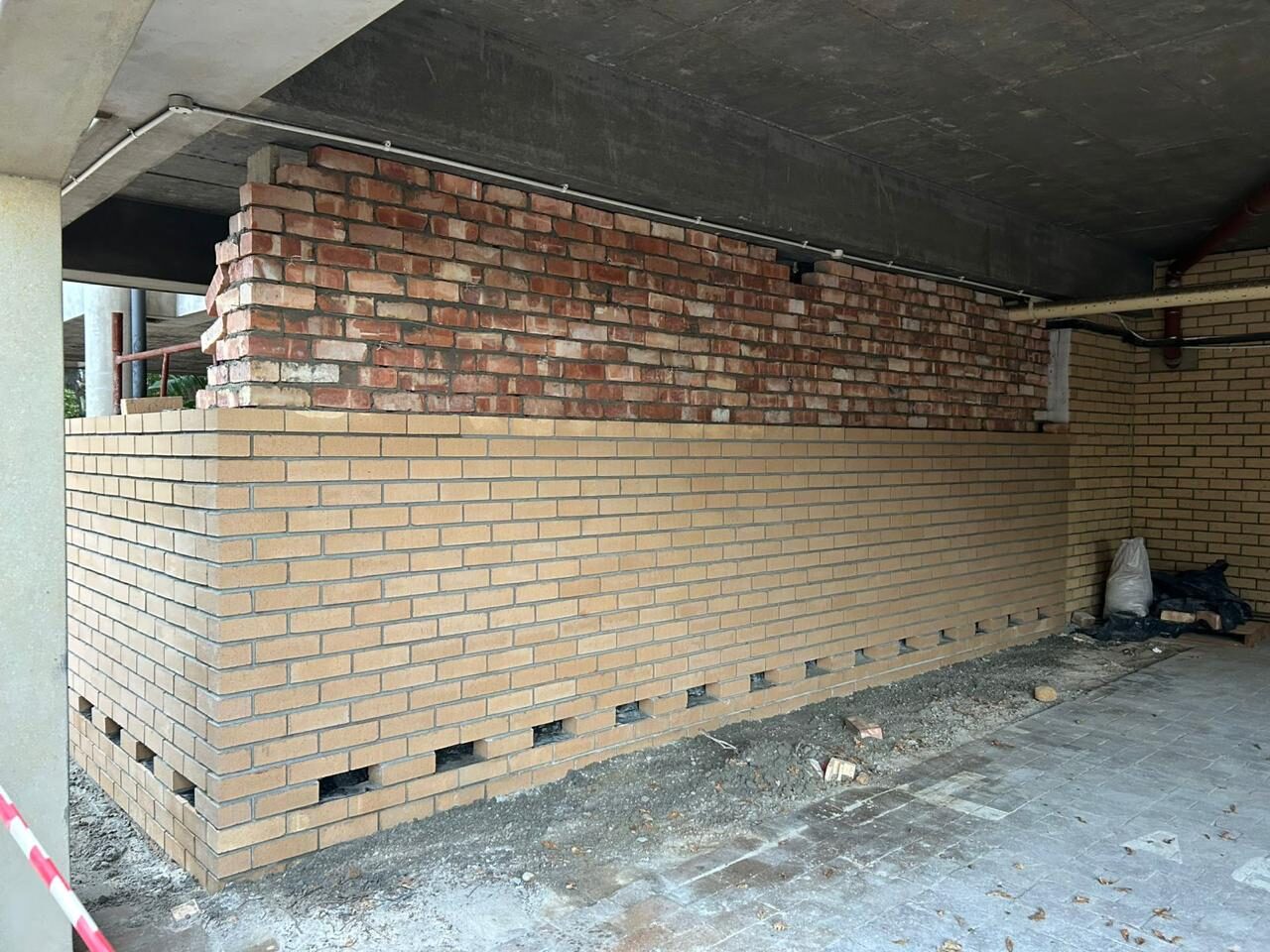 The near-complete enclosure — a long run of face brickwork closed off against the soffit