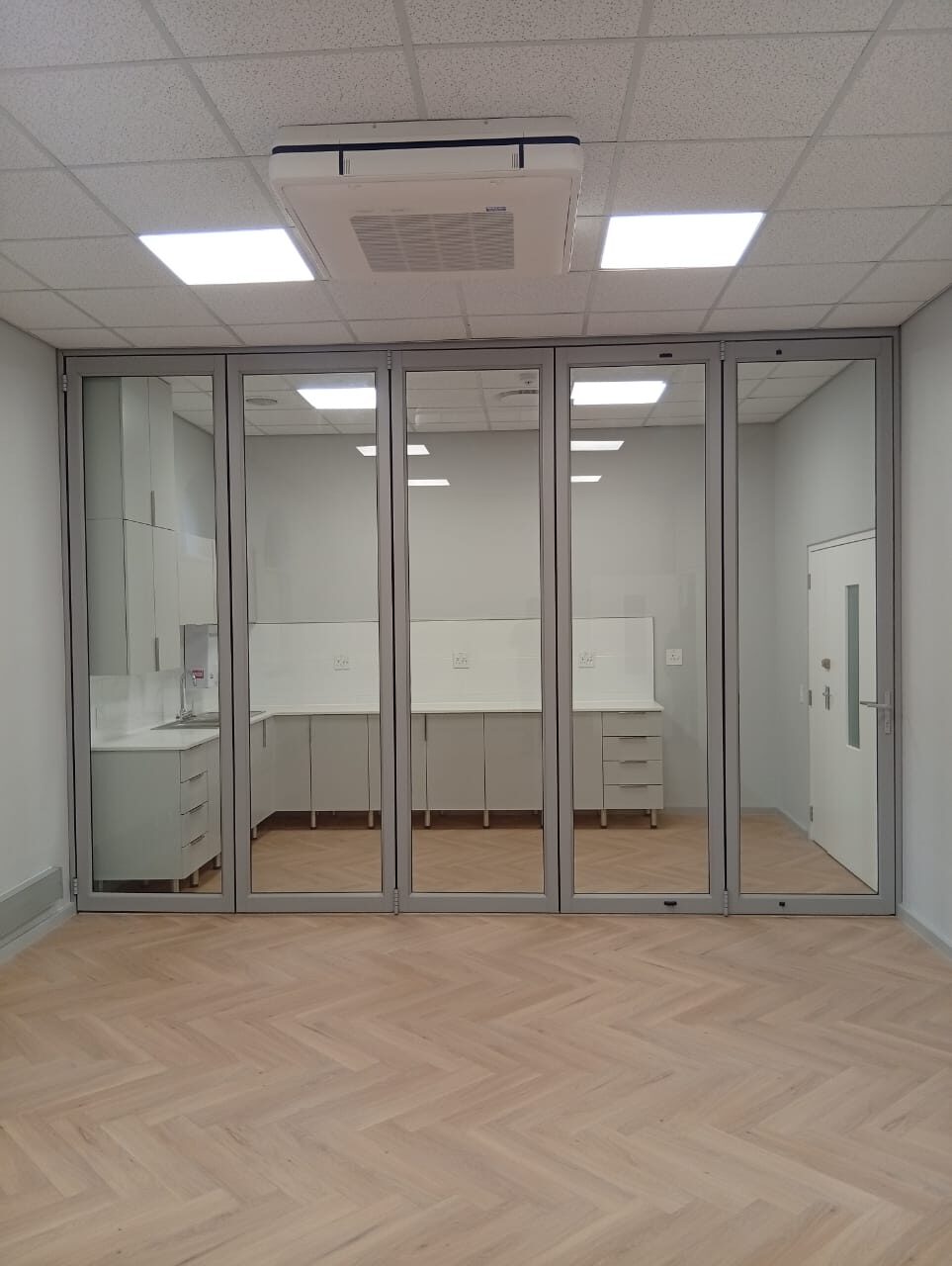 Fitted kitchenette behind new glass bi-fold partitions