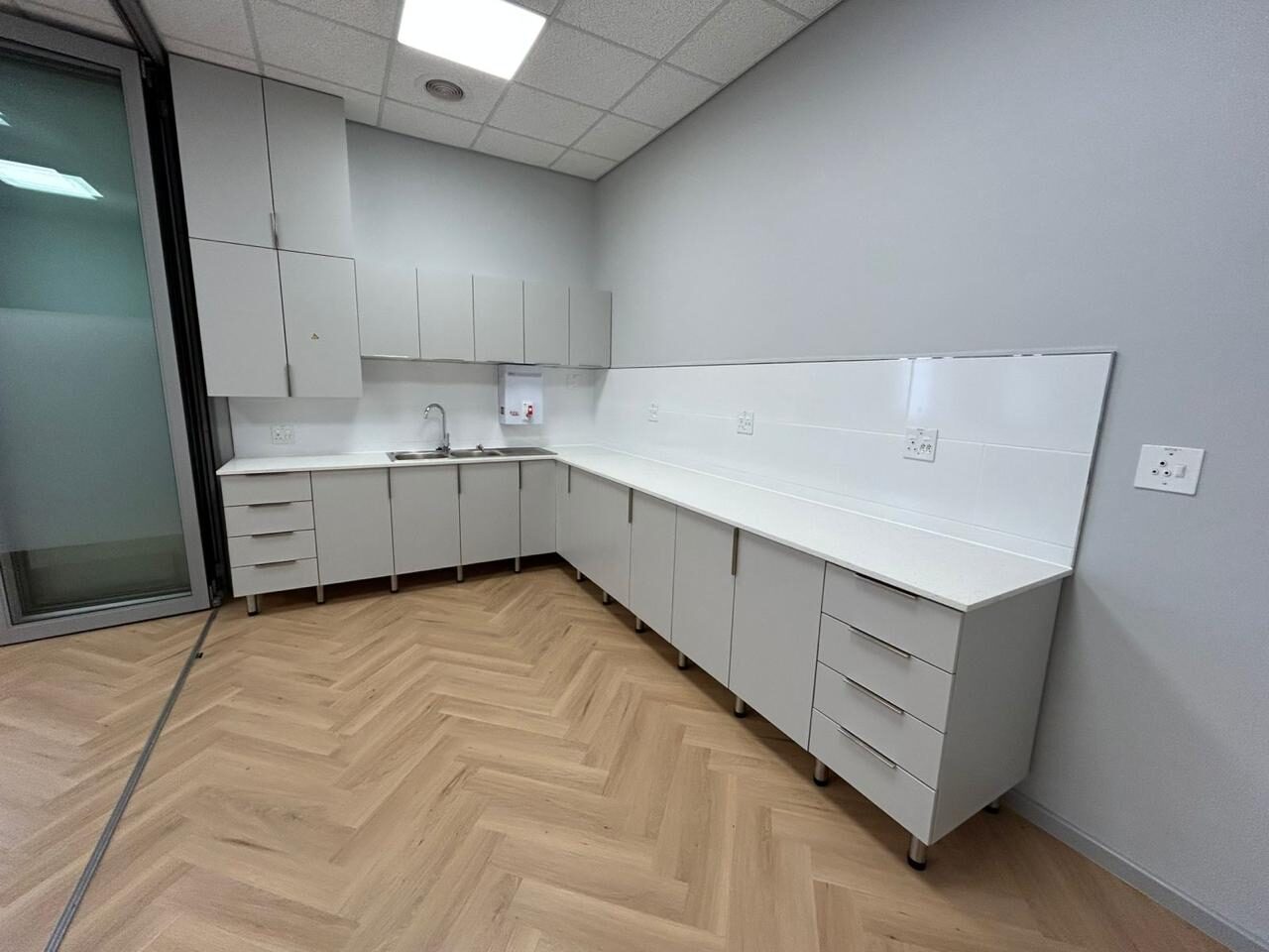 The finished room in use — fitted cabinetry, solid worktops and a herringbone floor laid throughout